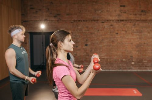 Group of adults exercising indoors with dumbbells, focused on fitness and health.