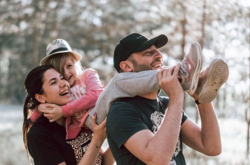 Happy family having fun in a forest, capturing joyful bonding moments.